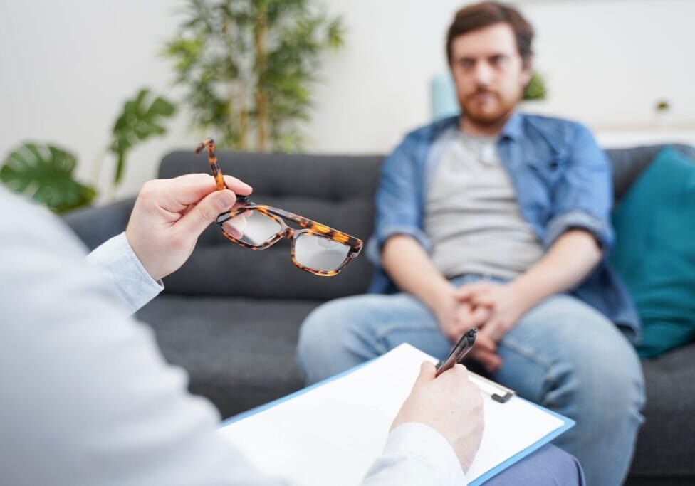 Doctor consulting male patient, working on diagnostic examination of mental illness